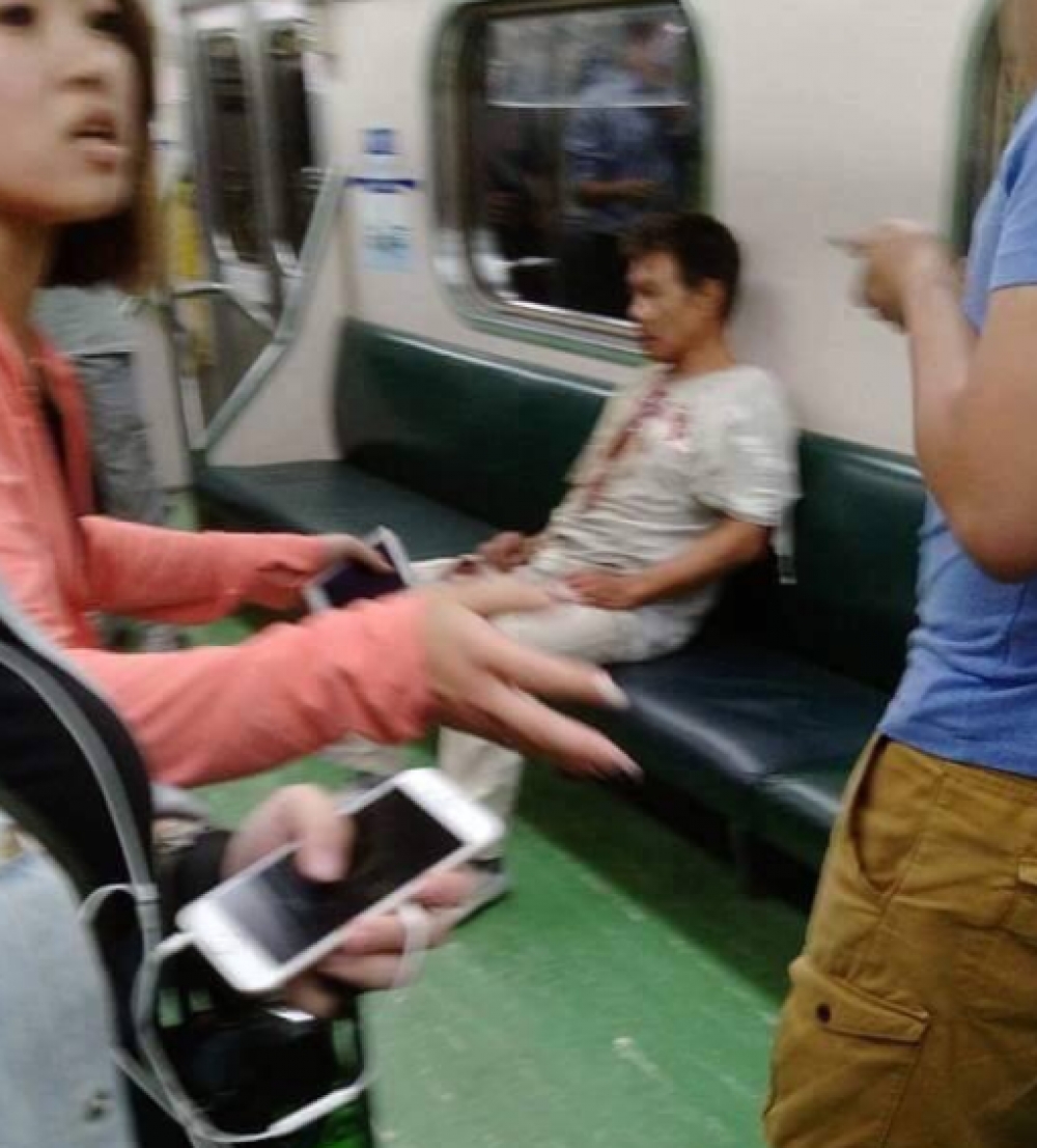 爆炸案發生後，一臉呆滯斜坐在列車座椅上，身上多處流血。（翻攝自爆料公社）