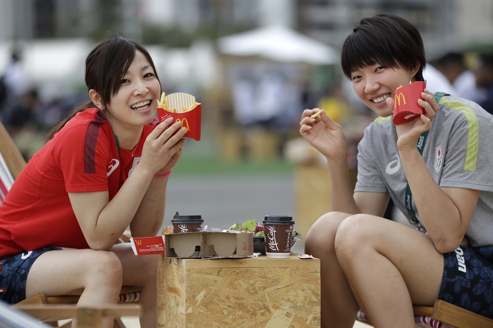 日本排球選手石井優希（左）與佐藤亞里紗（右）正享用麥當勞套餐（AP）