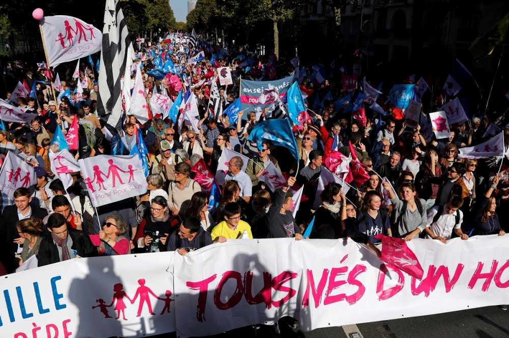 16日參與巴黎「為全民示威」（La Manif Pour Tous）運動的參與者持著旗幟與標語。（湯森路透）