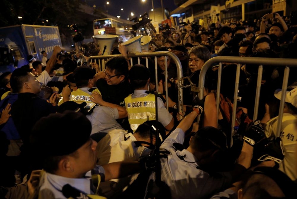 香港約4000名抗議群眾不滿人大將決定兩位新科立法會議員能否就職，6日晚間憤而衝撞中聯辦。  （湯森路透）