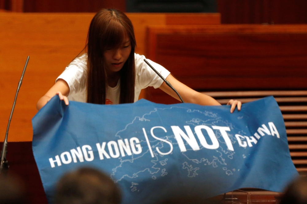 10月12日香港立法會宣誓就職時，本土派議員游蕙禎拿出「香港不是中國」（HONG KONG IS NOT CHINA）的旗幟。（美聯社）