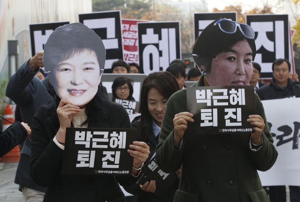 抗議者戴著南韓總統朴槿惠與崔順實的面具表達抗議。 （美聯社）