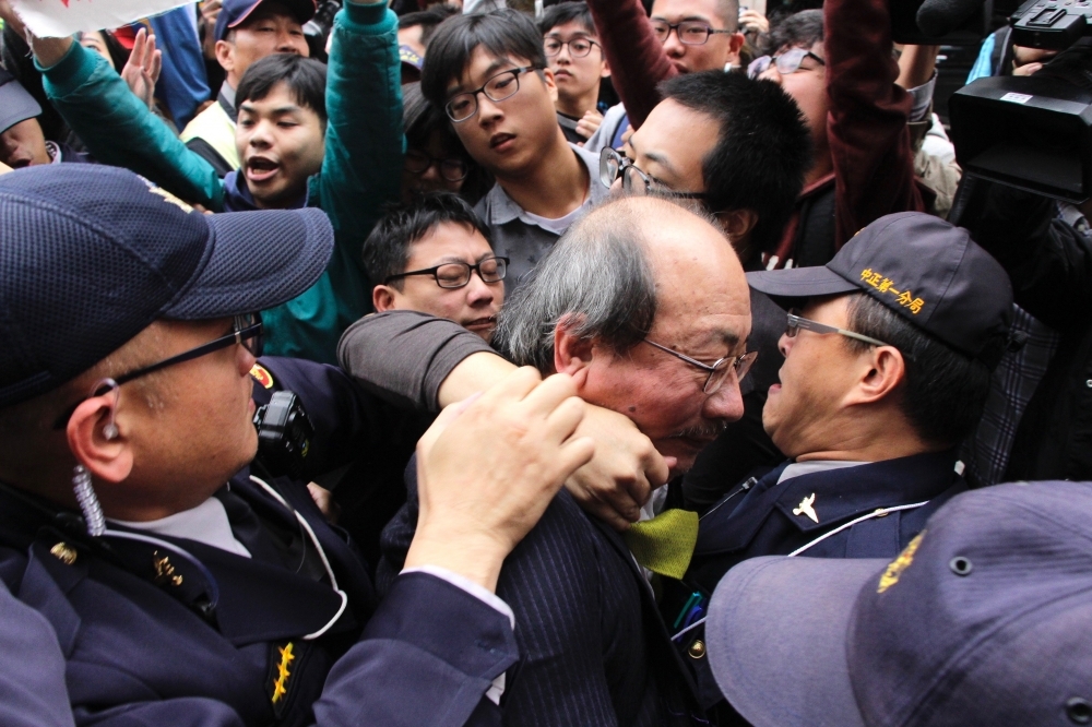 民進黨立院黨團總召柯建銘近遭抗議群眾勒頸、毆打頭部，還不慎跌倒在地。（攝影：李隆揆）