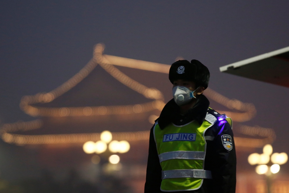 北京霧霾嚴重，警察戴著口罩站崗。（湯森路透）