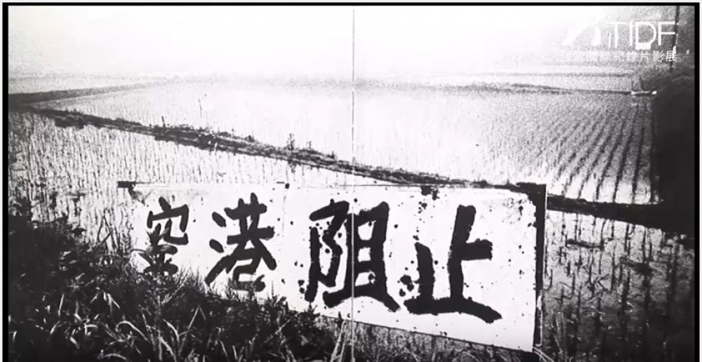 1991年參與日本三里塚抗爭協調的經濟學者宇澤弘文曾寫下《空港粉碎》一書，記述成田機場這一公共政策決策、推進的荒謬與殘忍。其內容和近年台灣的土地開發案情境頗為相似。（當年抗議成田機場開發案的標語／圖片翻攝自Youtube）
