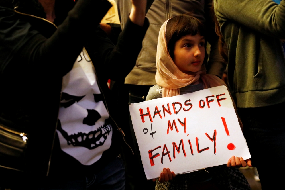 一名9歲孩童在美國機場抗議川普的移民政策。（湯森路透）