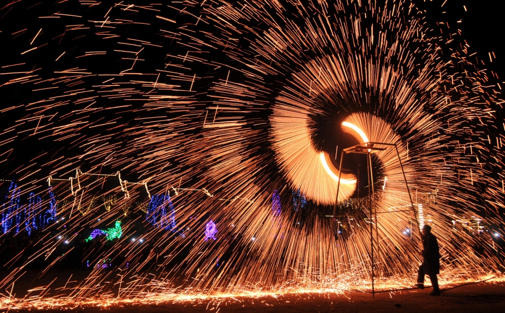 中國河南省安陽市的民俗藝術家揮灑鐵水慶祝元宵節。（湯森路透）