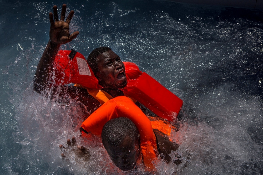 掉入地中海中的移民接受救援人員援助。（湯森路透）