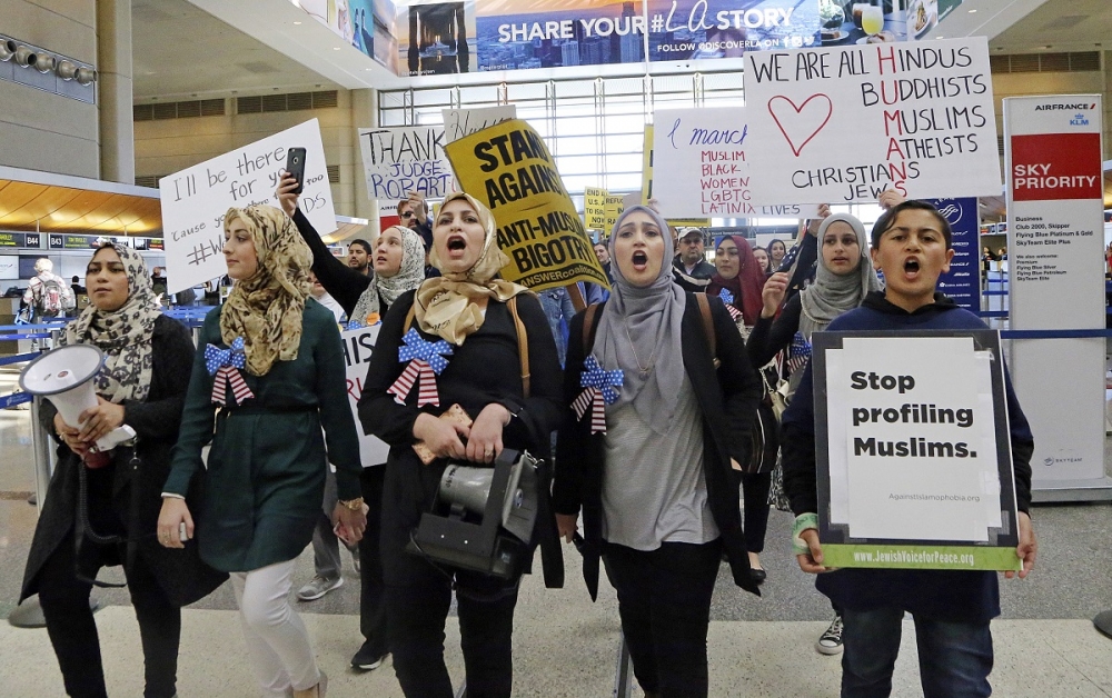穿戴穆斯林傳統頭巾的女性4日於美國洛杉磯國際機場參與示威活動。（美聯社）