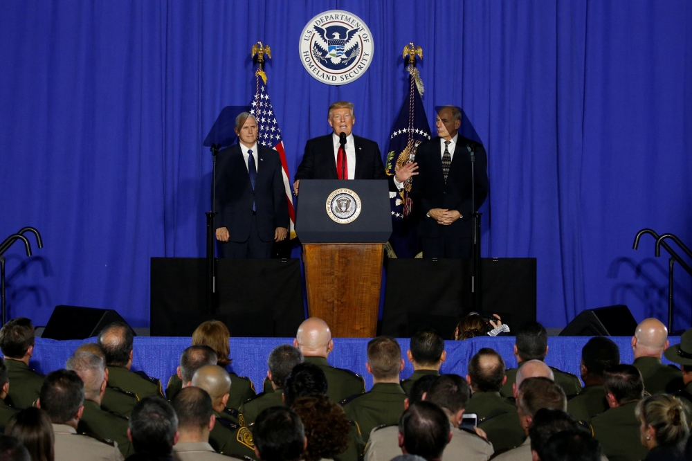 川普1月25日與副總統彭斯（Mike Pence）（左）和國土安全部部長凱利（John F. Kelly）（右）共同發表演說。（湯森路透）