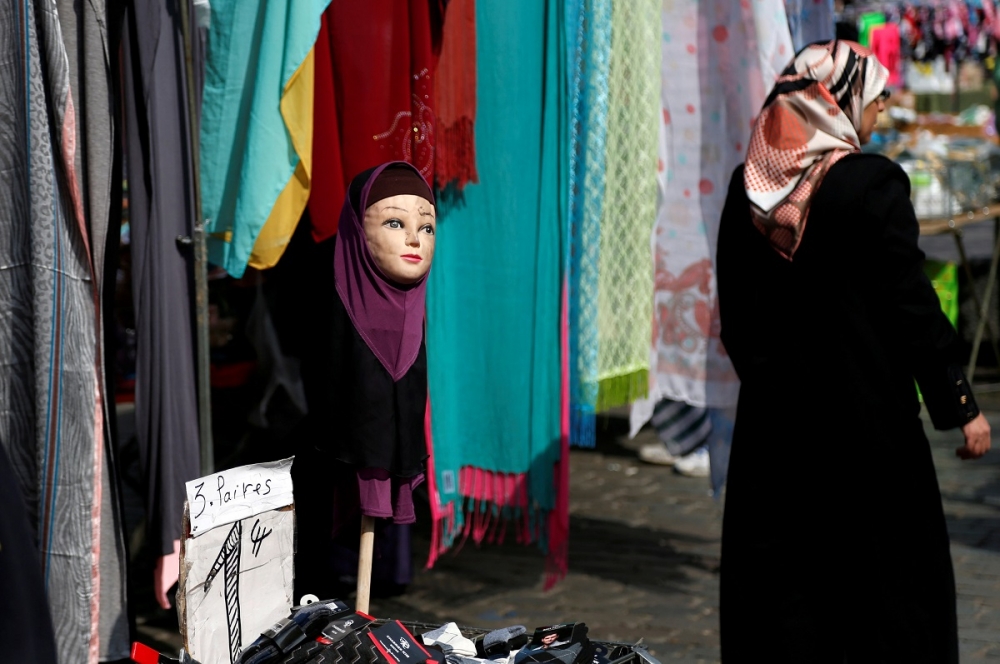 一名戴著頭巾的女性行經布魯塞爾一處市場。（湯森路透）