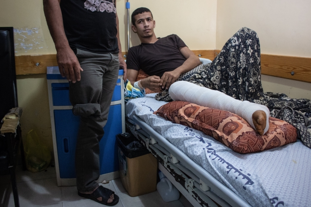 我們來到醫院探視遭戰爭受害的巴人，馬德洪恩（躺在床上者）自述是被以軍槍擊受傷，我們望向站在一旁照料他、少了右腿的父親，驚訝得知其父的殘缺竟是巴勒斯坦兩派鬥爭下的犧牲品。（攝影：李隆揆）