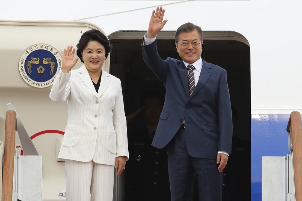 南韓總統文在寅（右）、南韓第一夫人金正淑（左）台北時間22日上午抵達美國，在專機艙門揮手向媒體、接機人員致意。（美聯社）