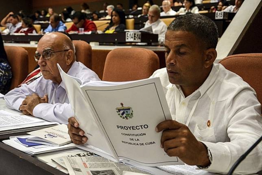 一名古巴全國人民權力大會成員閱讀新憲法草案。（美聯社）