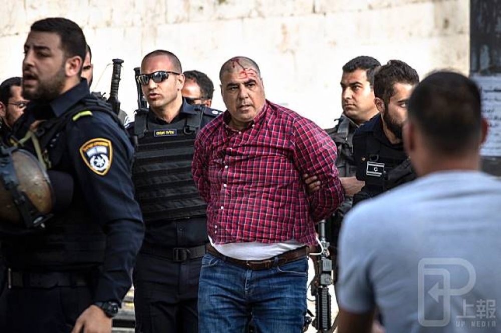 「主麻日」結束，一名穆斯林與以色列軍警起衝突，頭部受傷流血。（攝影：李隆揆）