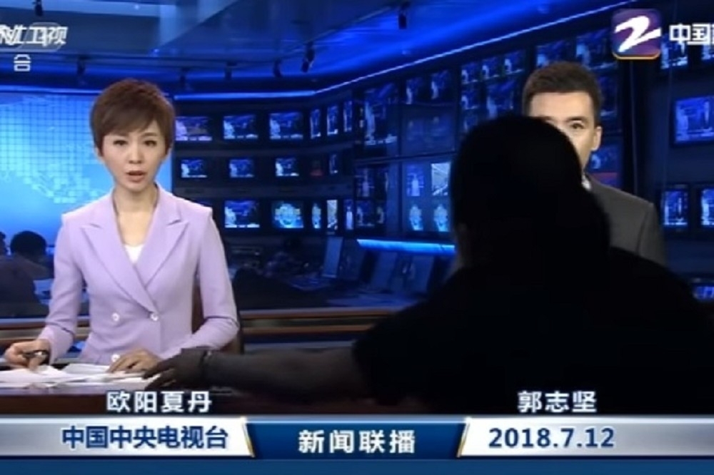 12日全國聯播的《央視》新聞畫面中出現黑衣人。（取自影片）