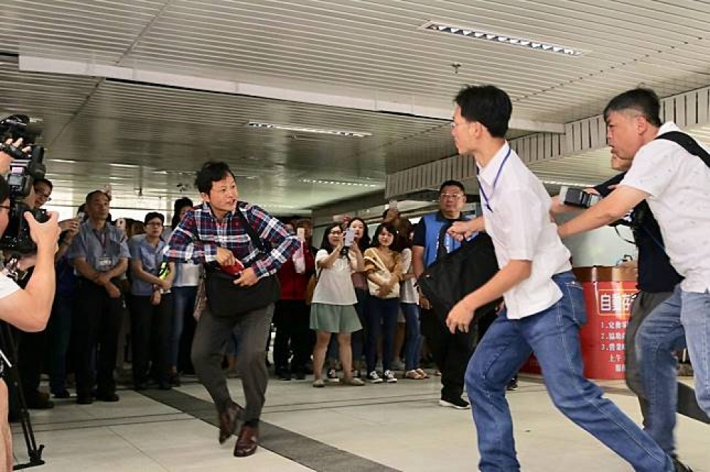 台灣國辦公室主任陳峻涵對台北市長柯文哲丟拖鞋抗議，大喊「不要做中共同路人」。（攝影：張凱婷）