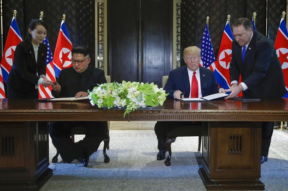 朝美雙方12日簽訂共同協議時，朝鮮勞動黨第一副部長金與正（左一）、美國國務卿蓬佩奧（右一）分別遞上鋼筆及文件。（美聯社）