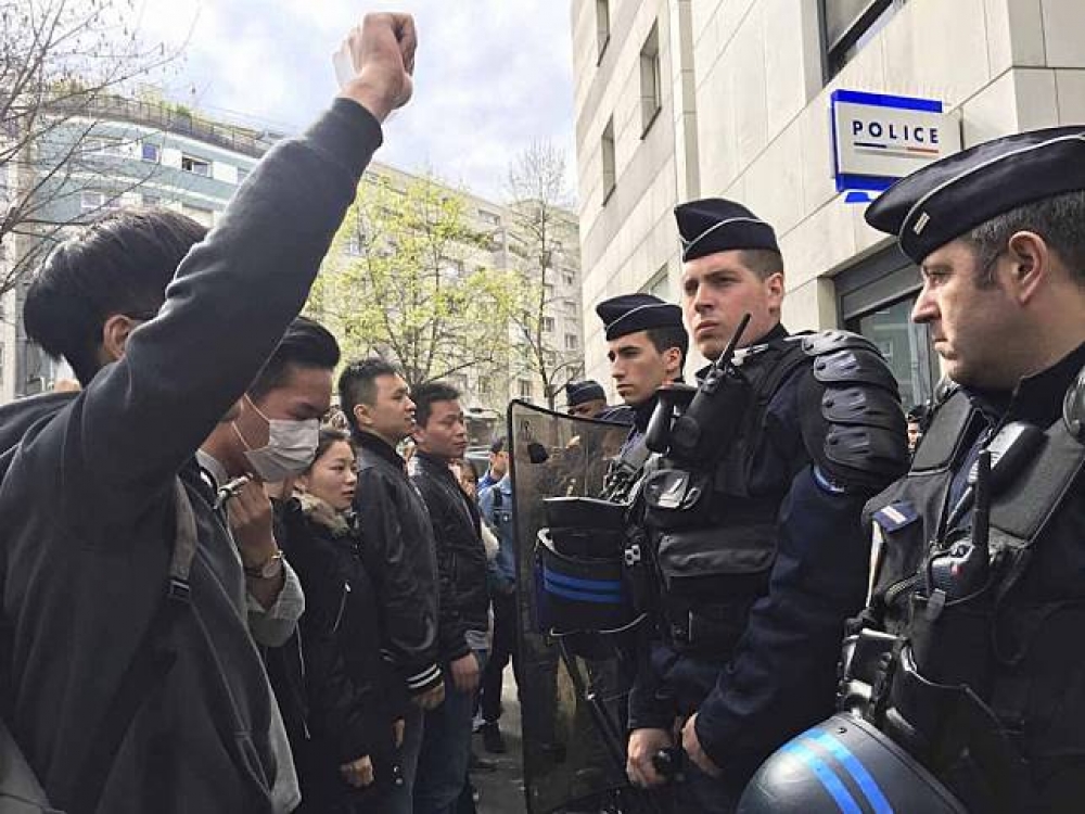 中國示威者聚集巴黎第19區警局外抗議，不滿一名中國籍男子據稱在家中遭法國便衣員警射殺的消息。（美聯社）