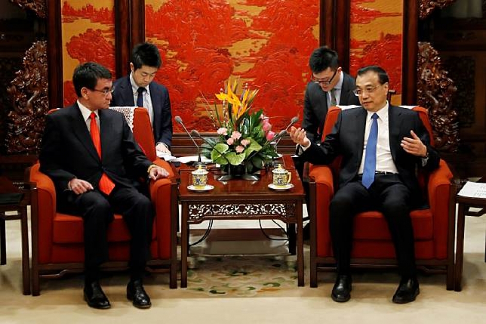 繼自民黨幹事長二階俊博應邀訪問北京之後，日本外相河野太郎（左）於上月27、28日訪問中國，正式邀請中國總理李克強（右）出席春天在東京舉行的中日韓領導人峰會。（湯森路透）