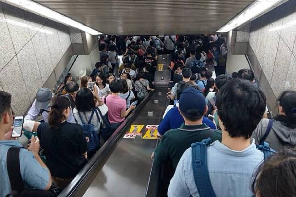 強颱瑪莉亞來襲，北北基下午4時起停班停課此許多民眾趕搭捷運返家，讓4點後的北捷各站從電扶梯到月台都擠滿人。（讀者提供）