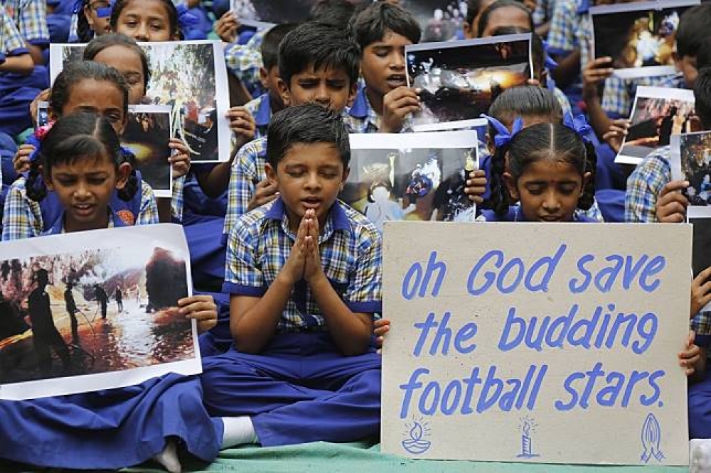 泰國小學生幫受困少年足球隊祈福、祈禱。（美聯社）