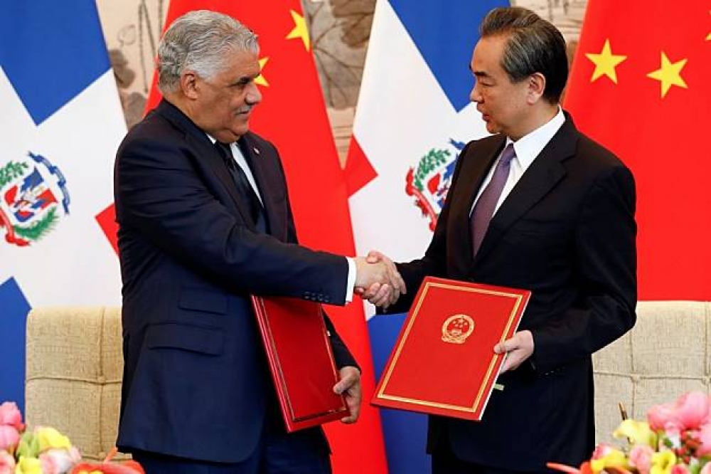 1日，中國外長王毅（右）與多明尼加外長巴爾加斯（左）於北京簽署建交公報。（湯森路透）