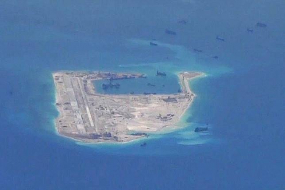 美國海軍5日提供一張照片，顯示中共疑似在南沙群島的永暑礁部署疏濬用船隻。（湯森路透）