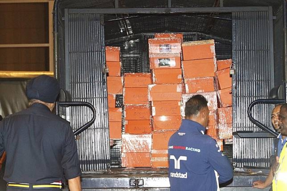 馬來西亞警方蒐出以橘盒裝的284只名牌包，價值不斐。（美聯社）