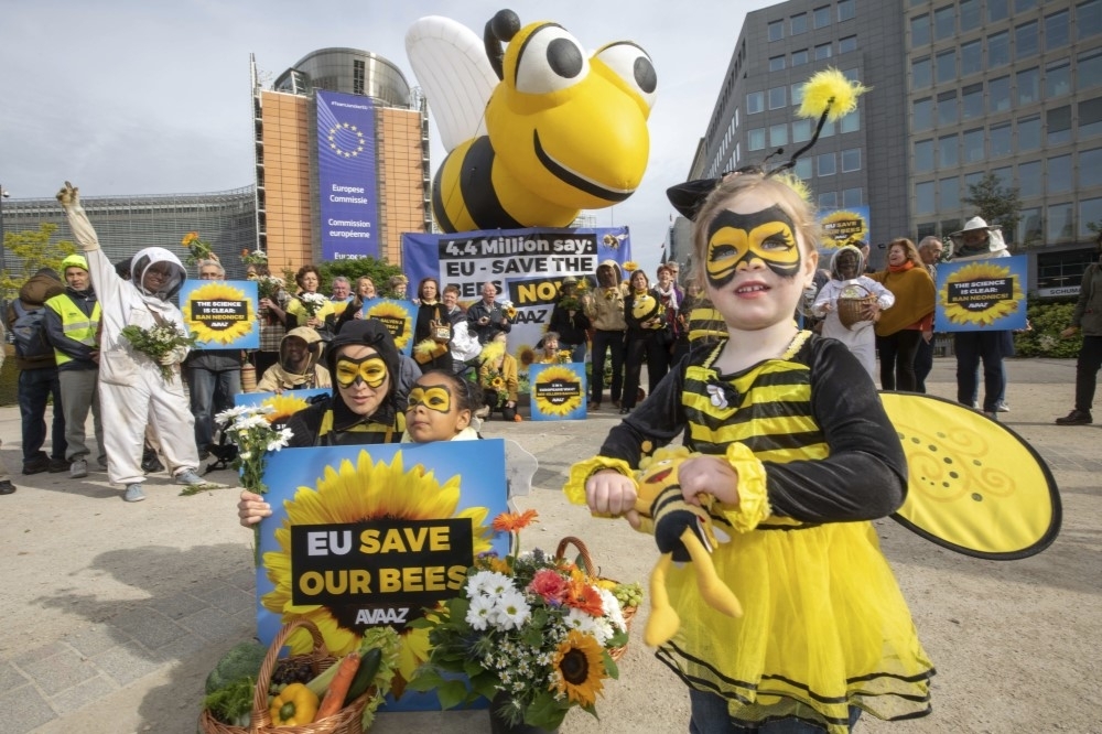 歐盟通過殺蟲劑禁令。圖為環保人士攜家帶眷到歐盟總部外穿蜜蜂裝聲援。（美聯社）
