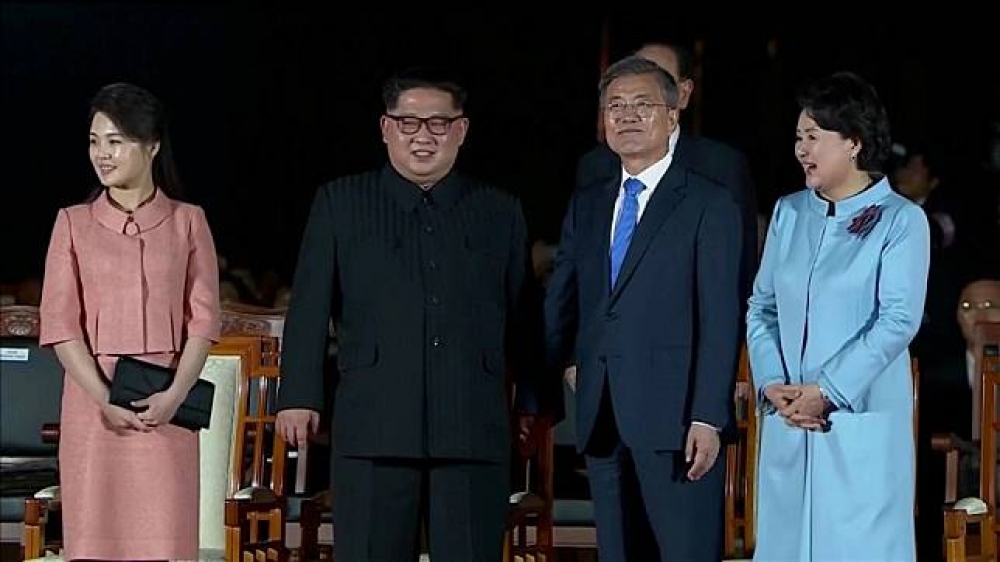 兩韓高峰會晚宴結束後，「和平之家」門外舉行歡送活動，文在寅和金正恩雙手緊握。（湯森路透）