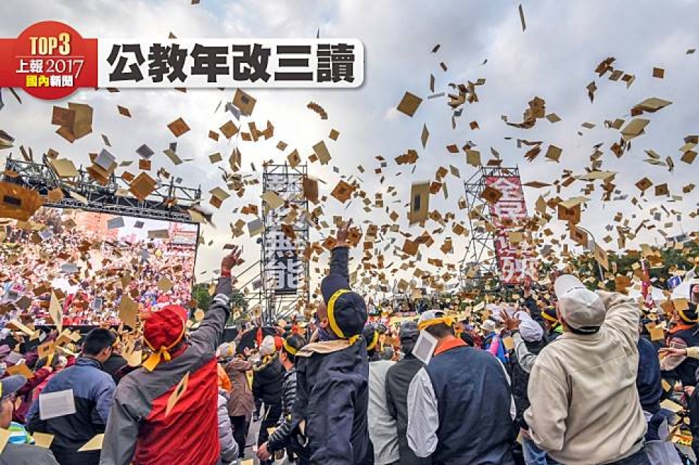 軍公教人員1月22日在總統府前高舉「全民遭殃」的牌子，只盼望在總統府裡的官員能夠聽到。（攝影：葉信菉）