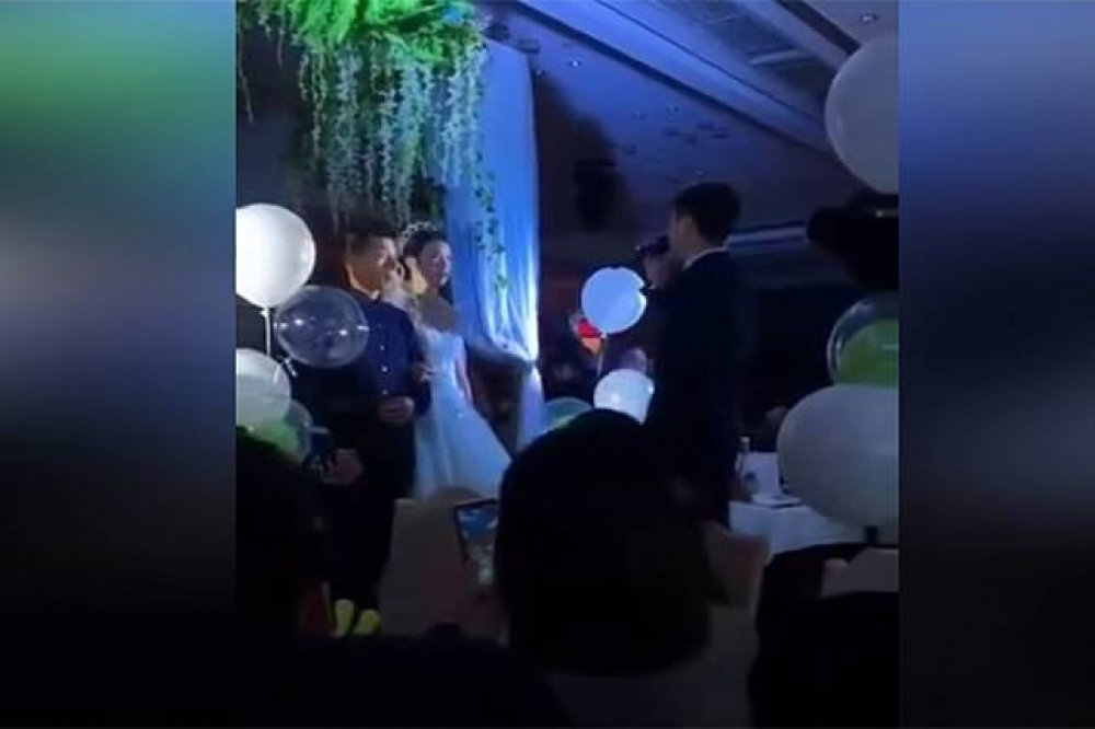 中國一名新郎在婚禮上對著新娘和岳父深情演唱《醜八怪》。（翻攝自YouTube）