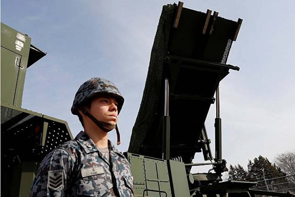 日本一名自衛隊隊員站在PAC-3前方。（湯森路透）