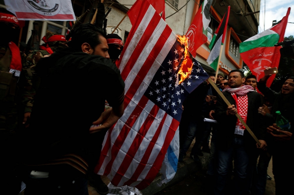 為了表示對川普承認耶路撒冷為以色列首都的不滿，巴勒斯坦民眾在街上燒起了美國國旗。（湯森路透）