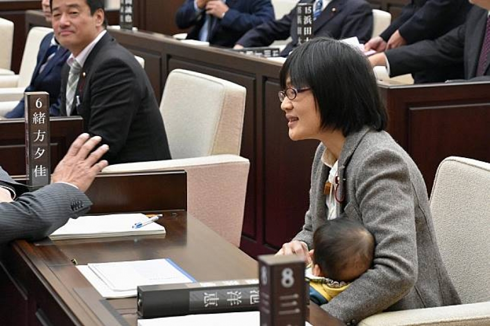 日本議員緒方夕佳抱著兒子。（湯森路透）