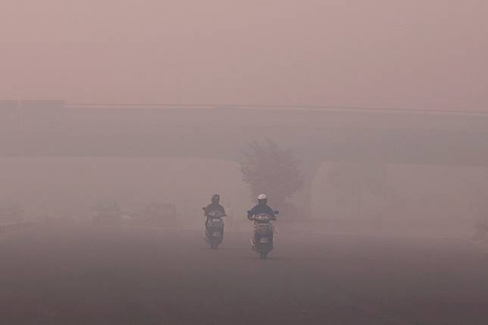 德里市霾害嚴重，市民在能見度極低的狀況下駕車。（湯森路透）