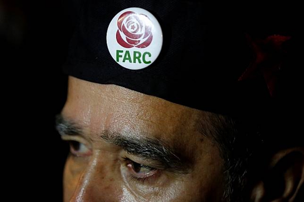支持FARC的哥國民眾配戴FARC的徽章。（湯森路透）