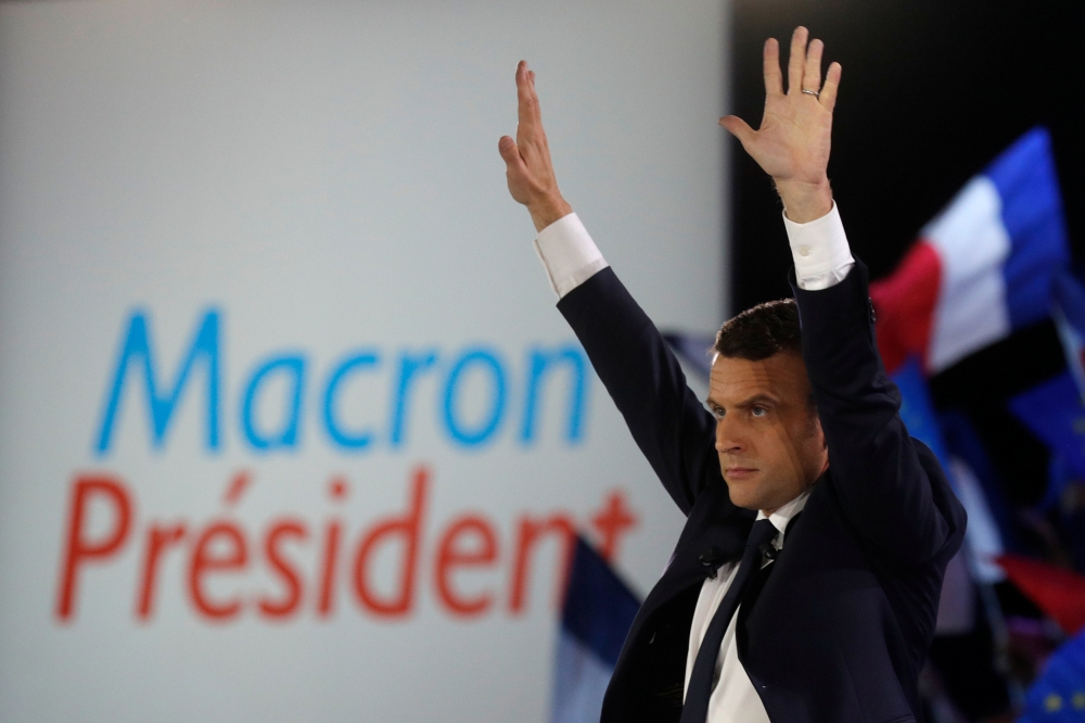 法國新任總統馬卡洪7日晚間偕同妻子接受支持群眾歡呼。（照片：湯森路透，後製：李明維）
