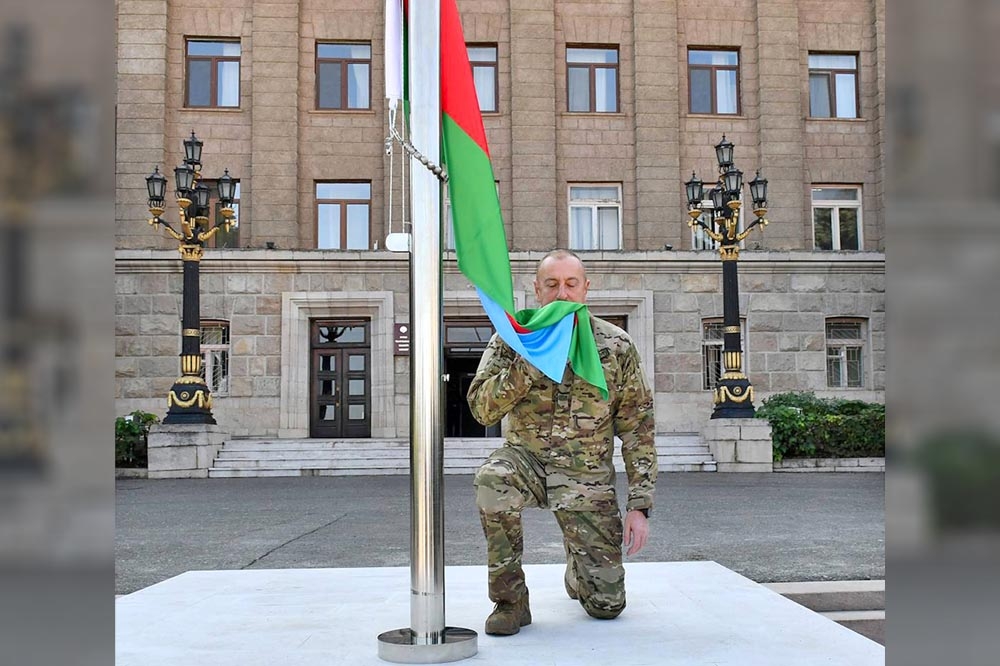 亞塞拜然總統阿利耶夫親赴納卡首府升旗宣誓主權，儀式開始前他先親吻國旗。（美聯社）