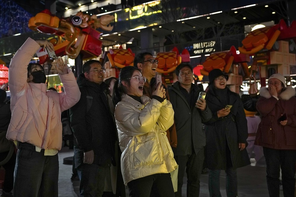 中國國安部示警，打卡有可能成為間諜幫兇。圖為15日時，北京一群路人在巨型樂高展示場所拍照。（美聯社）