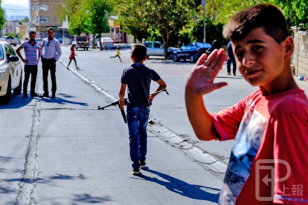 伊拉克庫德族自治區中持槍與行軍禮的孩童。（攝影：曾原信）