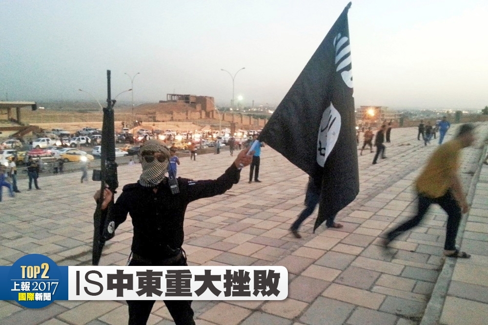 IS支持者2014年在摩蘇爾高舉IS旗幟。（湯森路透）