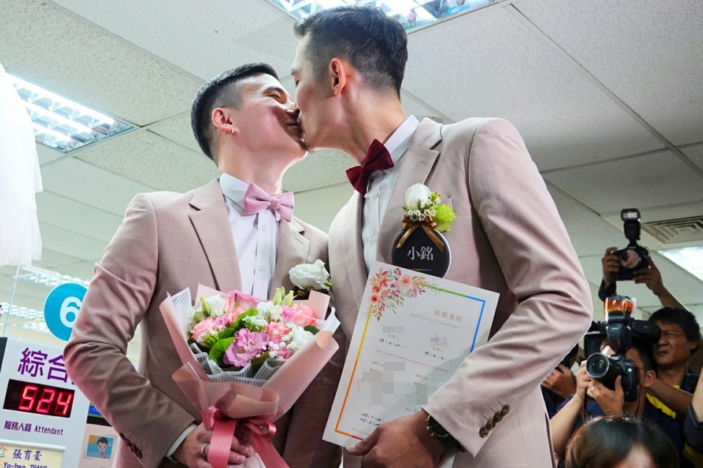 男同志新人小銘和小玄，辦理結婚登記時，兩人長吻1分鐘。(攝影：羅佳蓉)
