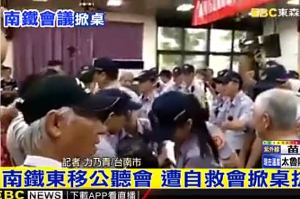 19日在台南市東區舉辦的第二場公聽會出現抗議民眾推擠、翻桌、灑冥紙的情形，場面失控。（翻攝自東森新聞）