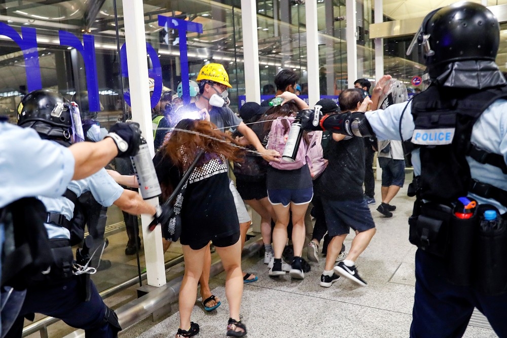 香港警察驅趕集結在機場的抗議民眾。（湯森路透）