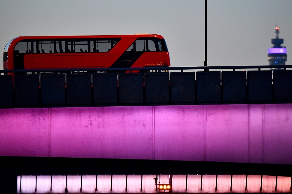 亮紅色的雙層巴士行駛在倫敦街頭格外顯眼。（湯森路透）