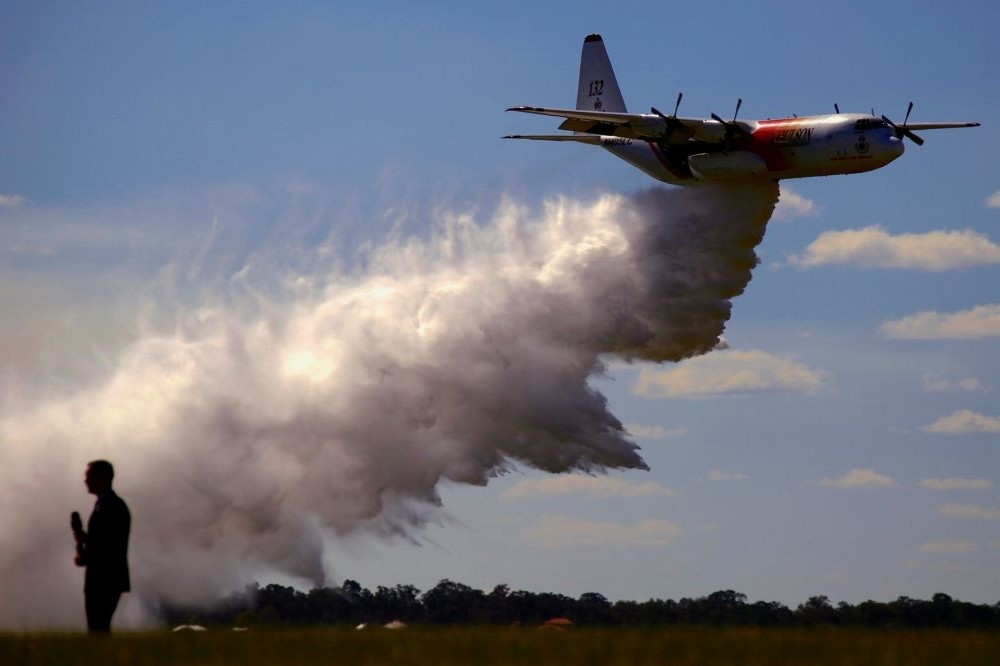 澳洲C-130運輸機噴灑滅火劑。（湯森路透）