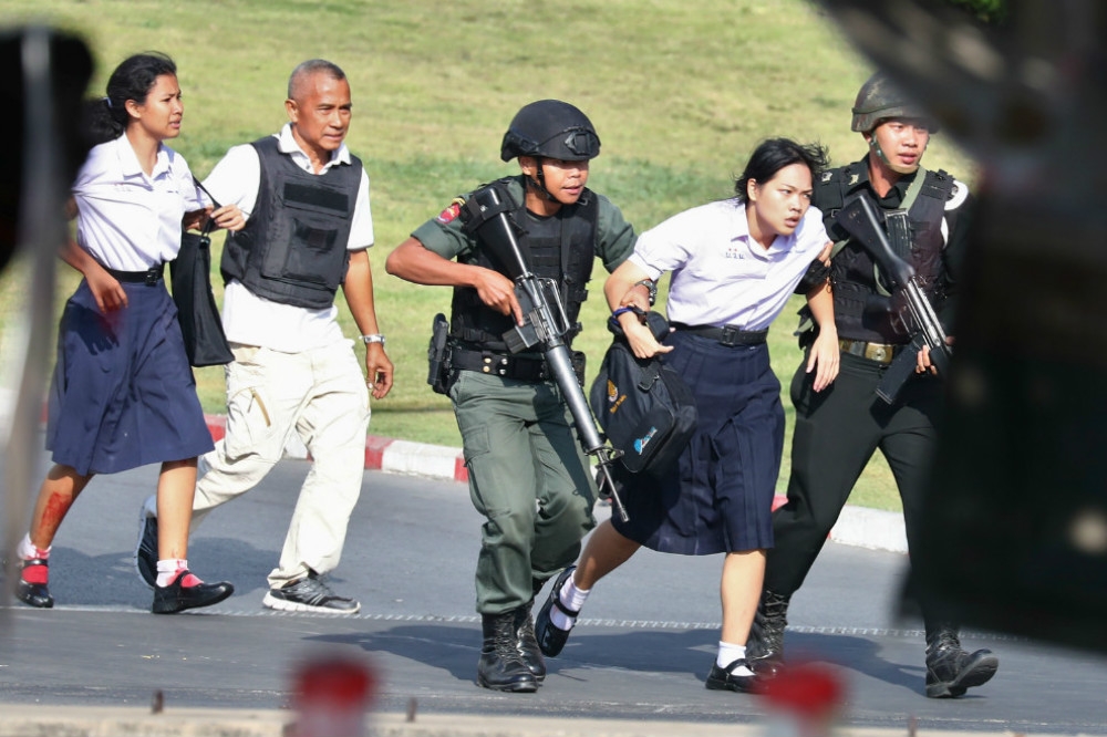 躲避槍手由特警隊護送逃離商場的泰國女學生。（湯森路透）
