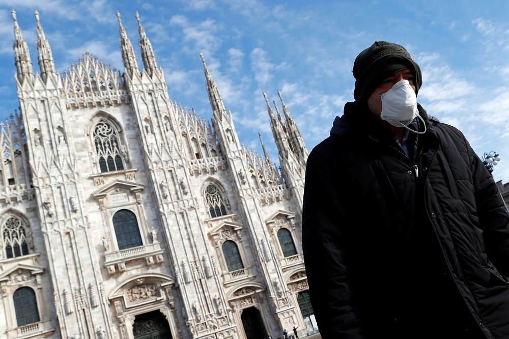 一名戴著口罩的男子，行經米蘭主教座堂（Duomo Cathedral）前方。（湯森路透）